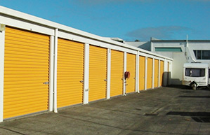 Row of drive-up storage units with a caravan parked in front